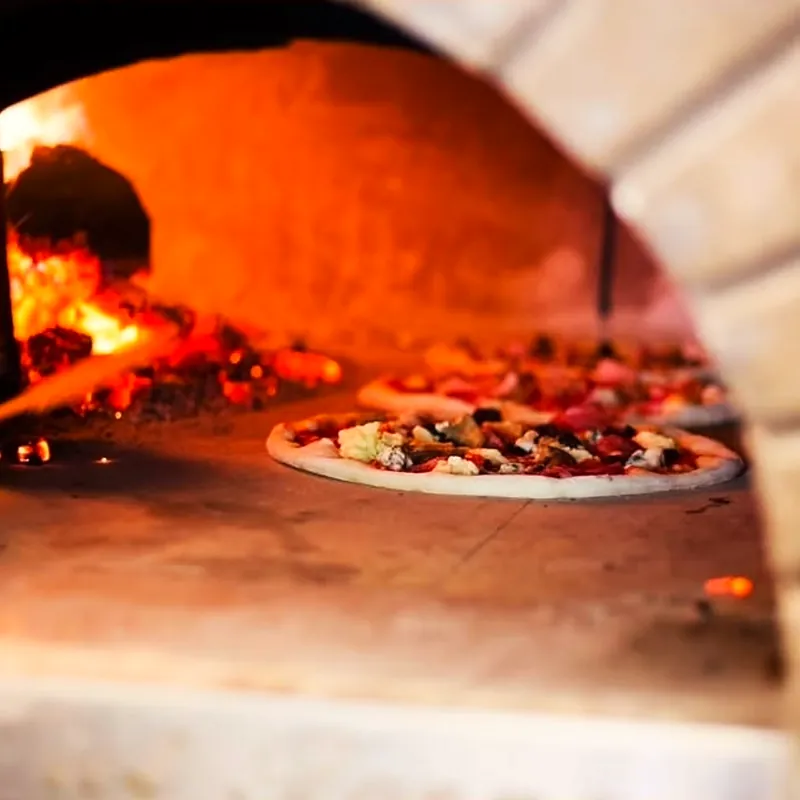 A pizza blistering in the wood-fired oven