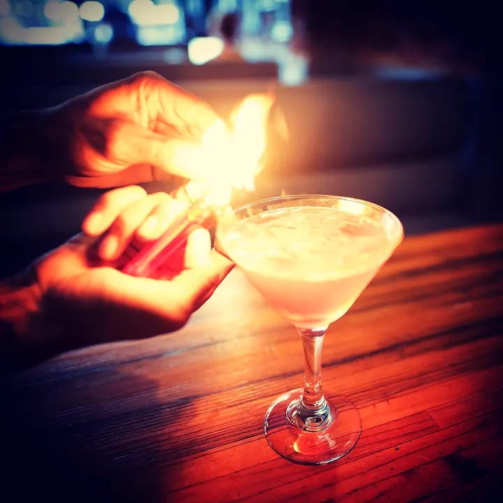 A cocktail being set alight at the bar