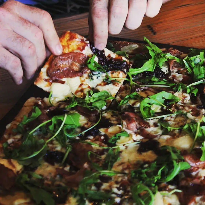 Hands reaching for a slice