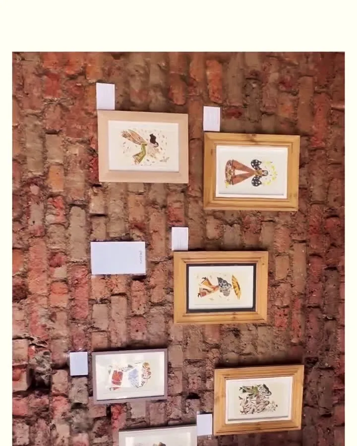 Framed prints by pezuni hung on the brick for a Rotating Walls exhibition