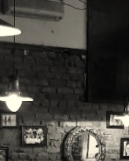 The brick wall of framed photographs under the pendant lamps